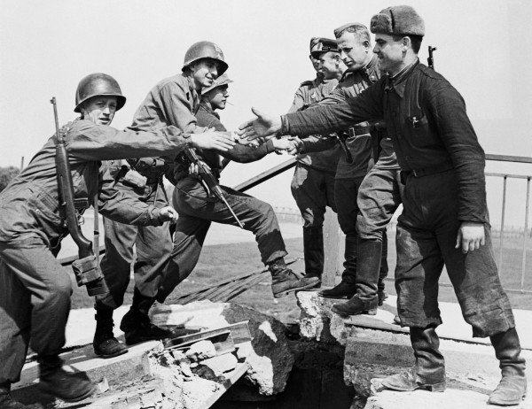 02 May 1945, Torgau, Germany --- Original caption: 5/2/1945-Torgau, Germany- This historic incident, which occurred on the wrecked bridge over the Elbe River at Torgau, shows the first meeting of American (L), and Russian soldiers as they reach out to grasp each other's hands. BPA2 # 5663 --- Image by © Bettmann/CORBIS